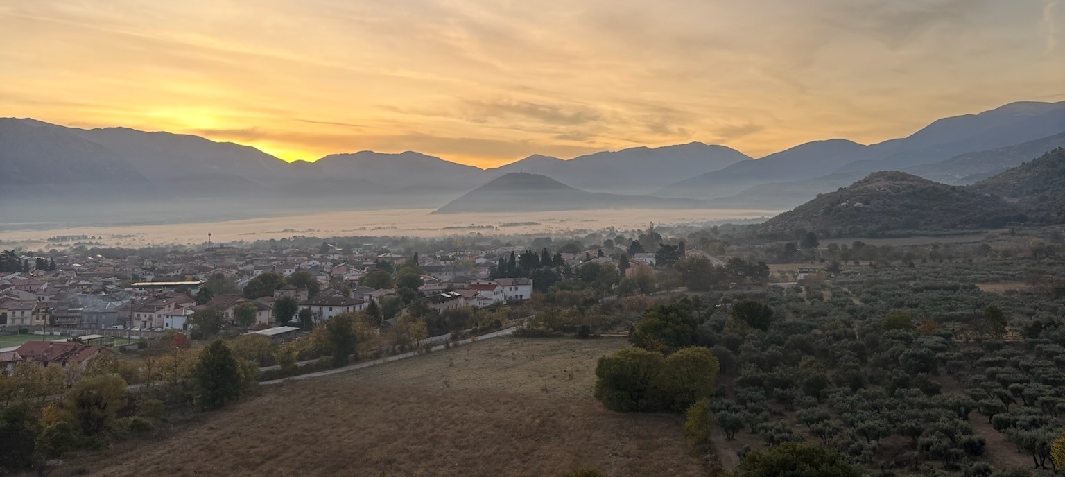 The Raiano valley at dawn, mountains rising over the village and groves